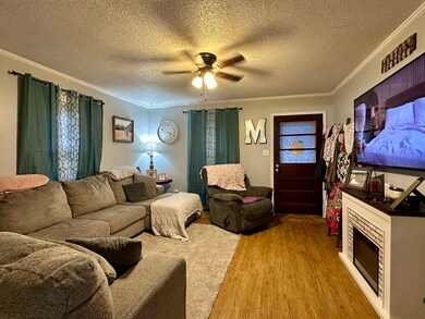 Living room with ornamental molding, a textured ce