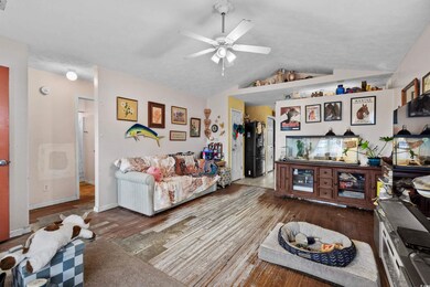Living room with wood-type flooring, vaulted ceili