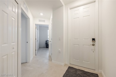 Corridor with baseboards, visible vents, and light