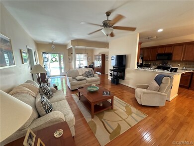 Living room featuring ceiling fan and light wood-t
