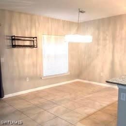 Unfurnished dining area with wood walls and tile p