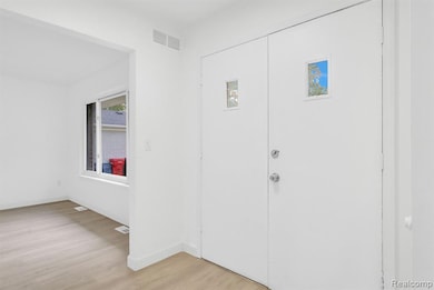 Entryway with light wood-type flooring and baseboards