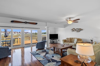 Living room with decorative columns, a ceiling fan, and hardwood / wood-style flooring