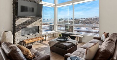 Living area featuring plenty of natural light, a stone fireplace, and wood finished floors