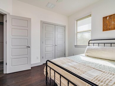 Bedroom with a closet, dark wood finished floors,