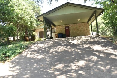 View of front of home with stone siding, driveway