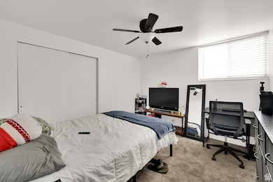 Bedroom with carpet flooring, an office area, and ceiling fan