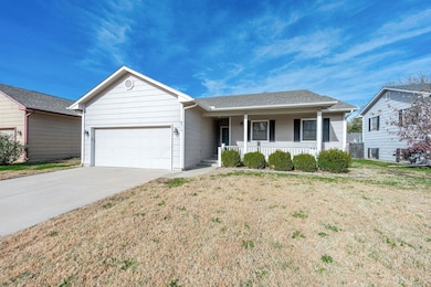 Single story home featuring covered porch, a front lawn, concrete driveway, an attached garage, and roof with shingles