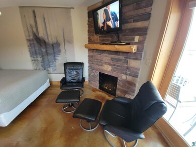 Bedroom featuring a fireplace and carpet