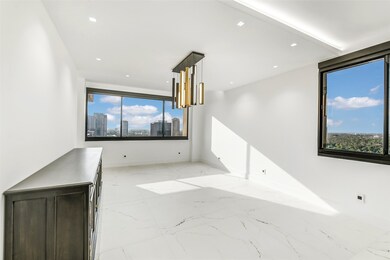 The formal dining room captures stunning views of the Galleria skyline and Memorial Park, creating a memorable backdrop for entertaining. A custom chandelier adds contemporary elegance, while a repurposed antique buffet brings a touch of timeless character—beautifully blending old and new.