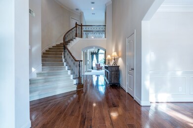 Upon entering this home, you step into the open foyer with a stunning winding staircase with iron railings! Beautiful hardwood hickory flooring flows into the formal dining room, living room, and down the hallway towards the family room!