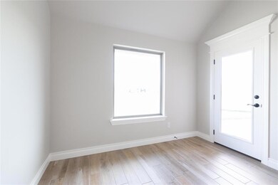 Unfurnished room with light wood-style flooring and lofted ceiling