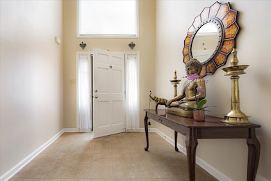 Entrance foyer featuring a towering ceiling and light tile patterned floors