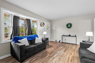 Living room features large bay window that lets in plenty of natural light.