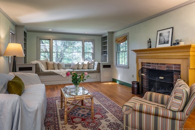Living room with wood burning fireplace and window seat