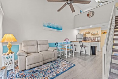 Living room with high vaulted ceiling, light hardw