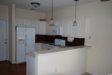 Kitchen with white cabinets, decorative light fixt