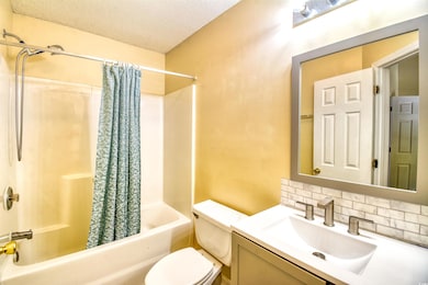 Bathroom with toilet, shower / bath combo with sho