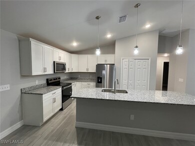 Kitchen with light wood-type flooring, pendant lig