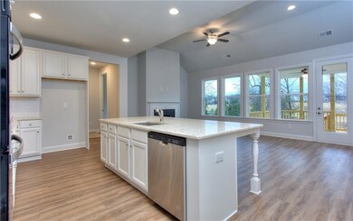 Kitchen with dishwasher, ceiling fan, baseboards, light wood-style floors, and white cabinetry