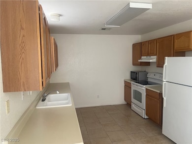 Kitchen with white appliances, under cabinet range