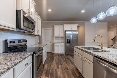 Kitchen featuring sink, white cabinets, and stainl