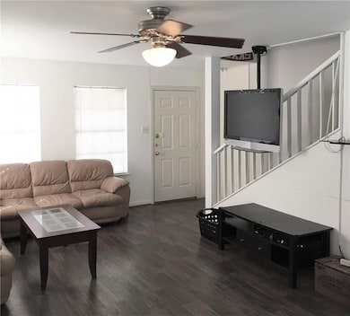Living area featuring a ceiling fan and wood fini