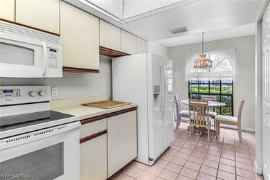 Kitchen with white appliances, hanging light fixtu