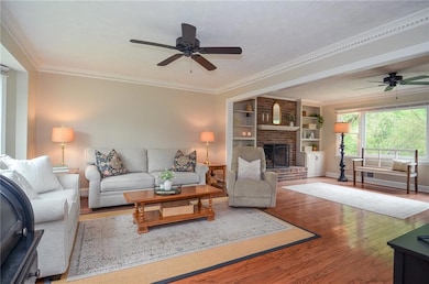 Living room featuring a ceiling fan, baseboards, a