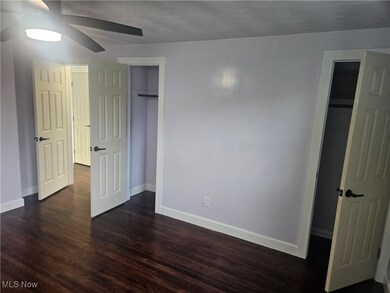 Unfurnished bedroom featuring dark wood-style flooring and a ceiling fan