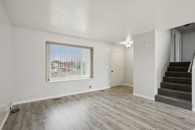 Unfurnished living room with light wood-style flooring and stairs