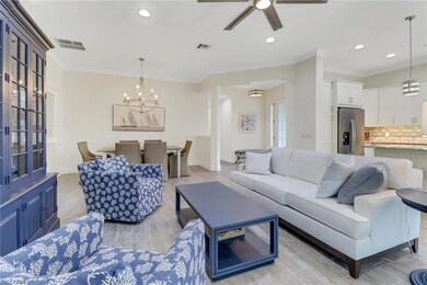 Living area with a chandelier, baseboards, recessed lighting, a ceiling fan, and crown molding