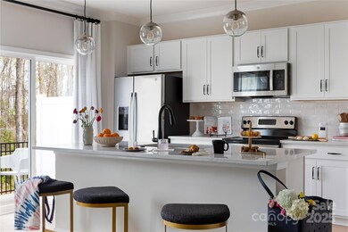 GE Stainless steel appliances and designer selected pendant lighting and touches.  *Model Photos | Actual finishes, structural selections, and orientation may vary.