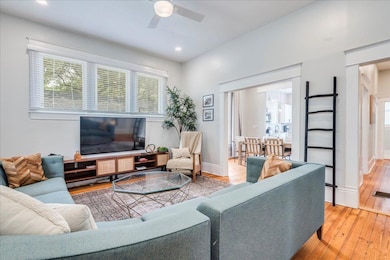 Living room with a ceiling fan, light wood-style 