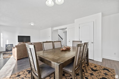 Dining area featuring baseboards and dark wood-style flooring