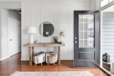 Foyer with craftsman features, hardwood floor and coat closet.