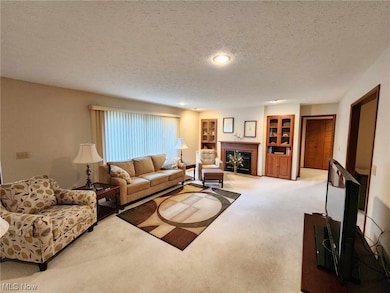 Carpeted living room with a textured ceiling