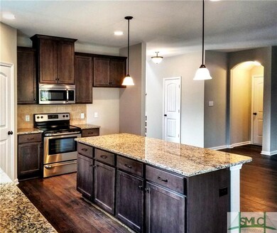 Large, open kitchen with island, granite, and stai