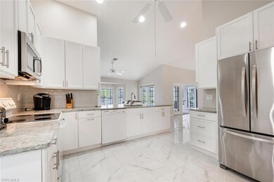 Kitchen with appliances with stainless steel finishes, ceiling fan, a peninsula, a sink, and backsplash
