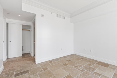 Unfurnished bedroom featuring stone tile floors, b