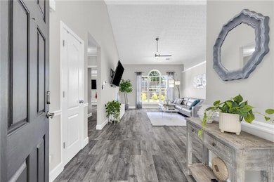 Entrance foyer with wood finished floors and a ceiling fan
