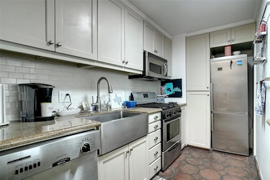 Kitchen featuring sink, light stone countertops, a