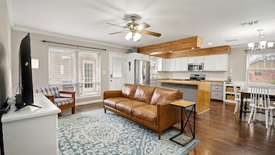 Open-concept layout with the living room flowing seamlessly into the updated kitchen. Large windows bring in great natural light, making the space feel bright and welcoming.
