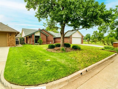 View of front facade with concrete driveway, a front lawn, brick siding, and central AC