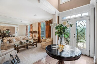 Foyer featuring ornamental molding, wood finished floors, and a chandelier