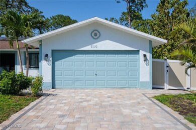 Garage featuring a gate and decorative driveway