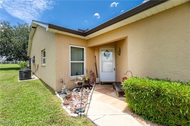 Doorway to property with stucco siding and a lawn