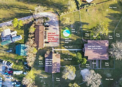2280 SqFt Manufactured Building, 2800 SqFt Lodge With 12 Dog Suites & 1954 SqFt Cottage With 10 Kennels & 2 Cage-Free Daycare Areas, Cross-Fenced Play Yards With Multiple Covered Concrete Pads/Porches & Splash Pad, & Spring-Fed Pond Surrounded By Trees.