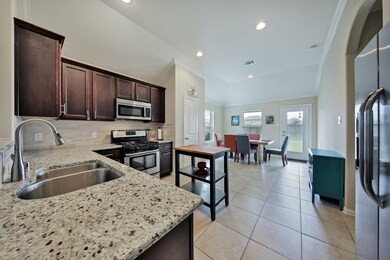 Your gourmet kitchen awaits you! Granite counters, stainless steel appliances. Breakfast area leads to the covered back patio. To the right is the laundry room complete with shelving.