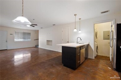Kitchen with stacked washer / dryer, stainless steel appliances, a ceiling fan, and decorative light fixtures